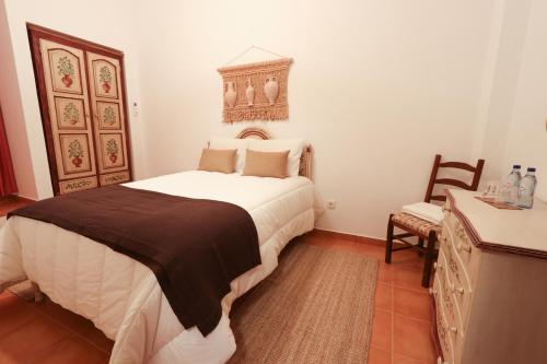 a bedroom with a large bed and a table and chair at Casa do Feitor - Monte da Graça in Elvas