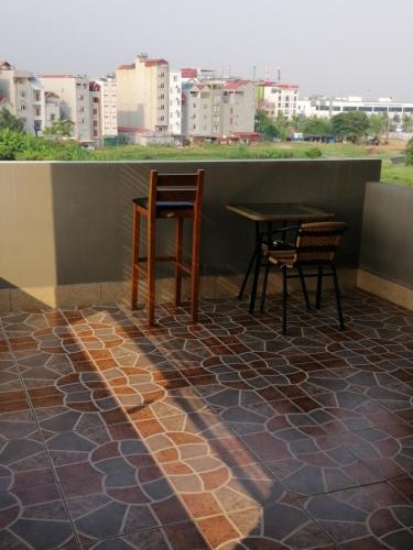 a patio with two chairs and a table on a roof at Roma Hotel Noi Bai airport in Hanoi