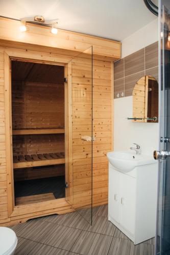 a bathroom with a shower and a toilet and a sink at Domek Aleksander z basenem, banią ruską i sauną in Sulęczyno