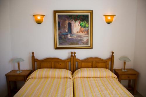 a bedroom with two beds and a painting on the wall at Apartamentos Parque Mar in Cala d´Or