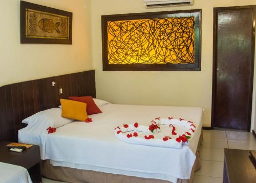 a bedroom with a bed with roses on it at Hotel Aconchego Porto de Galinhas in Porto De Galinhas
