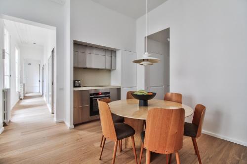 une cuisine et une salle à manger avec une table et des chaises dans l'établissement Modern Apt 3BDR/3BTH - Louvre Museum/Tuileries, à Paris