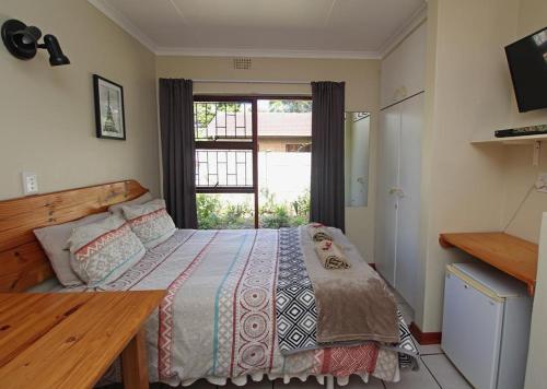 a bedroom with a bed and a window at Haven on Hoopoe in Sedgefield
