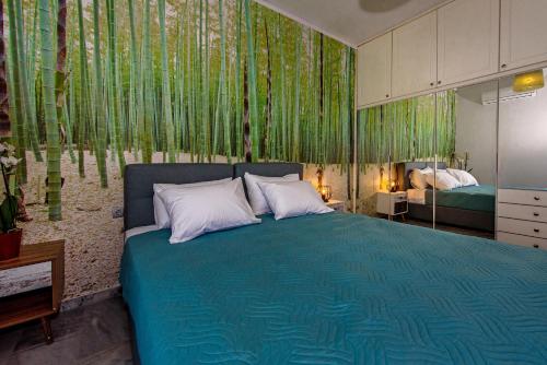 a bedroom with a blue bed with green wallpaper at Platanias Villa Spyros in Platanes