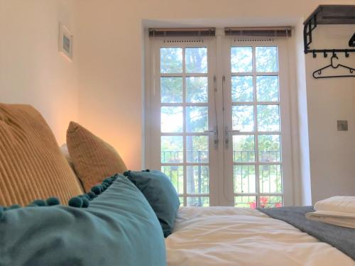 ein Schlafzimmer mit einem Bett und zwei großen Fenstern in der Unterkunft Seaside Cottage with Parking in Worthing