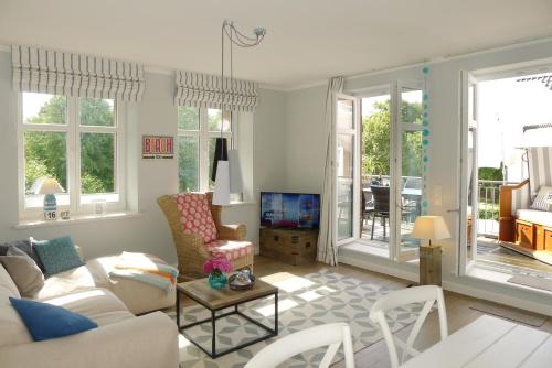 ein Wohnzimmer mit einem Sofa und einem Tisch in der Unterkunft Villa De Meere Whg 8 in Nieblum