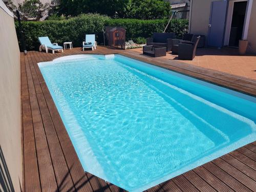 une grande piscine bleue sur une terrasse en bois dans l'établissement Appartement Villa Marcel Cottreau, à Marseille