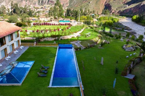 an aerial view of a swimming pool in a grass field at Taypikala Deluxe Valle Sagrado in Urubamba