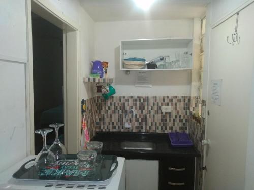 a small kitchen with a sink and a mirror at Apto Frente a Praia em Santos in Santos