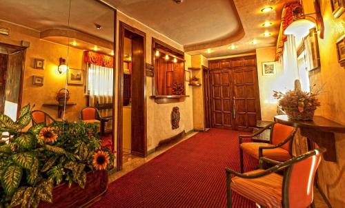 a lobby with a red carpet and a room with chairs at Hotel Rosa Serenella in Bardonecchia