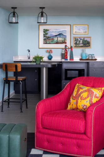 a living room with a red couch and a table at Graduate by Hilton Fayetteville, AR in Fayetteville