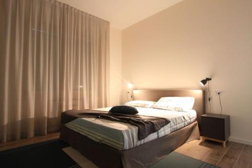 a bedroom with a bed and a window with curtains at casa Agrifoglio in Terralba