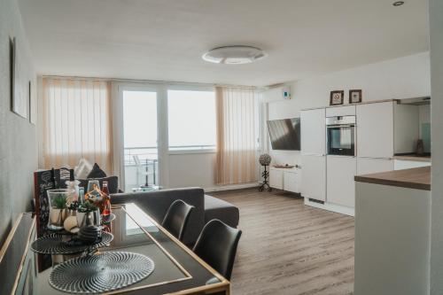 a living room with a dining table and a kitchen at Ferienwohnung " Panoramablick " mit Hallenbad Berg und Seesicht in Oberteuringen