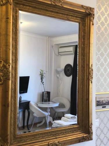a mirror reflecting a room with a table and chairs at Belle Apartments-Elegance Apartments in Belgrade