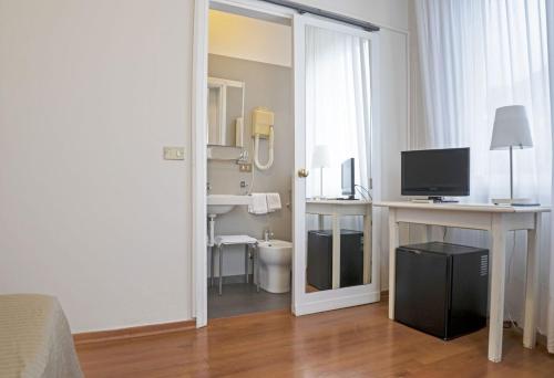 Cette chambre comprend une chambre avec un bureau et une télévision. dans l'établissement Hotel Positano, à Bassano del Grappa