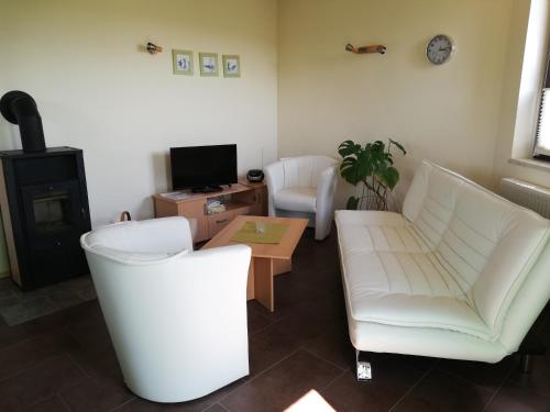 ein Wohnzimmer mit einem weißen Sofa und einem Tisch in der Unterkunft Ferienhaus Edeltraud in Dargen