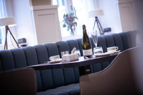 a table with a bottle of wine and glasses on it at Villa Rein Boutiquehotel in Bad Reichenhall