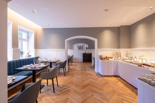 a restaurant with tables and chairs and a counter at Villa Rein Boutiquehotel in Bad Reichenhall