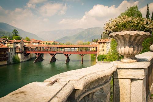 a bridge over a river with a train on it at Hotel Positano in Bassano del Grappa