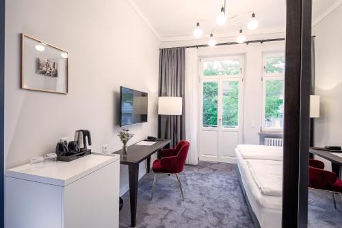 a hotel room with a desk and a couch at Villa Rein Boutiquehotel in Bad Reichenhall