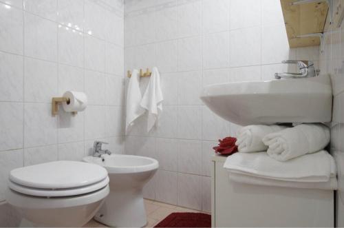 Un baño blanco con inodoro y lavabo. en La casa di Remo, en Roma