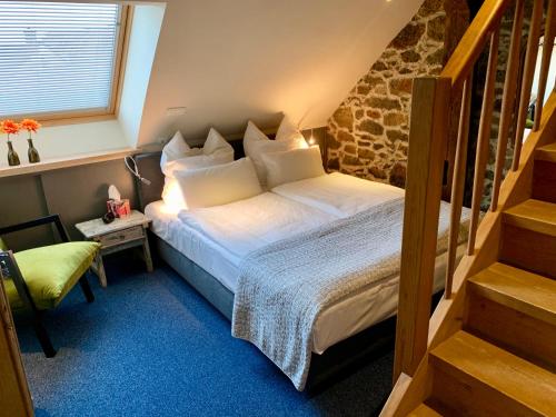 a bedroom with a bed with white sheets and a staircase at Historische Ferienwohnung mit Sauna in Lich in Lich