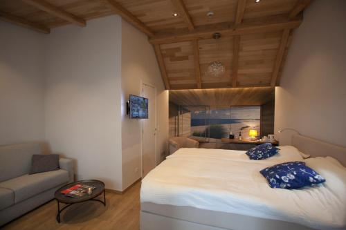 a bedroom with a large bed and a couch at Huyze Fleur B&B in Knokke-Heist