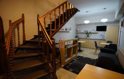 a staircase in a living room with a kitchen at Dolce Vita Panzió in Miskolc