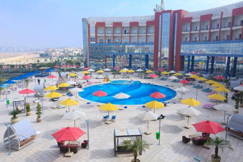 a courtyard with a pool with umbrellas and tables at Tolip El Narges in Cairo