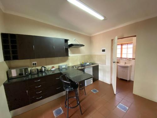 a kitchen with black cabinets and a counter top at Lanseria Country Estate in Lanseria