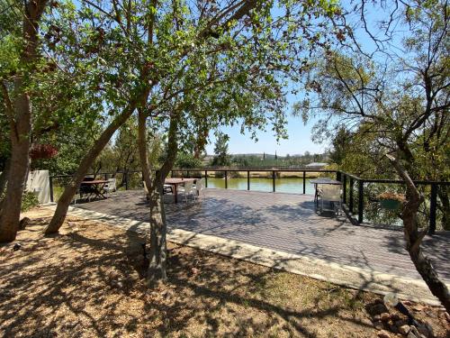 a wooden deck with a picnic table and benches at Lanseria Country Estate in Lanseria