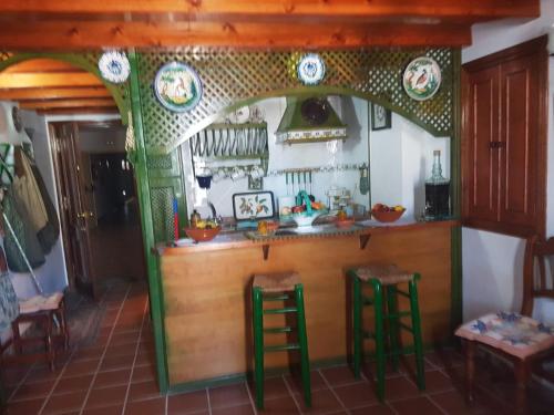 a bar in a kitchen with green stools at Apartamento de Lujo en Puente del Rey El Rocio in El Rocío
