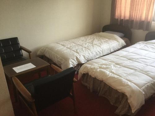 Habitación con 2 camas, escritorio y silla. en Homestay Dream / Vacation STAY 5063 en Uonuma
