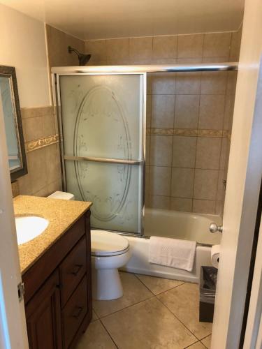 een badkamer met een douche, een toilet en een wastafel bij Galt Ocean Drive Beach Condo in Fort Lauderdale