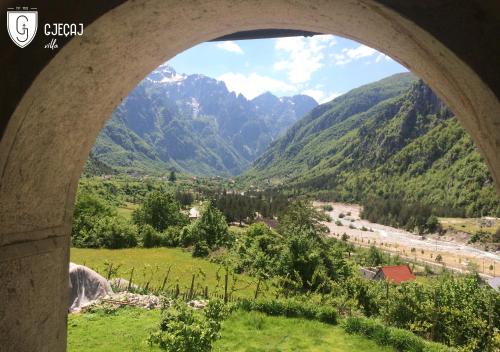 a view of a valley through a stone archway at Villa Gjeçaj Guesthouse and Restaurant in Theth