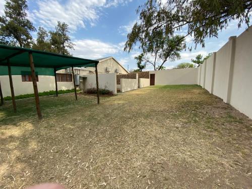 an empty yard with a fence and a building at Lanseria Country Estate in Lanseria