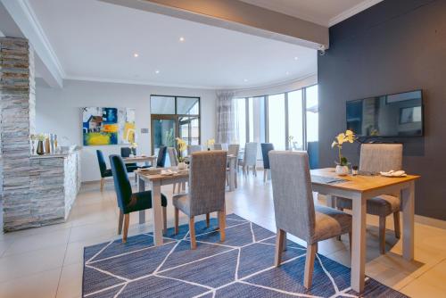 a dining room with a table and chairs at Bay Lodge on the Beach in Mossel Bay