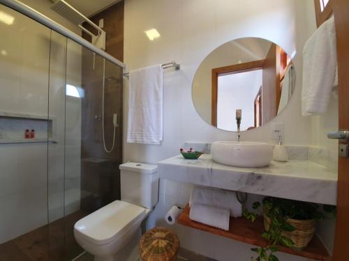uma casa de banho com um lavatório, um WC e um espelho. em Pousada Vila Santa Maria em Pirenópolis