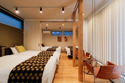 金沢市にあるMALLOWK in Kanazawaのベッド4台とバルコニーが備わるホテルルームです。