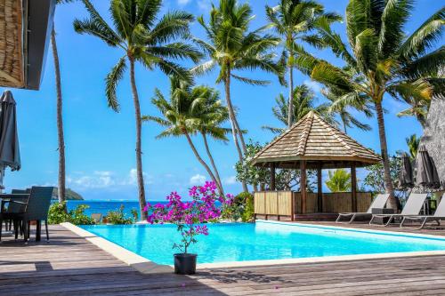 a pool at a resort with palm trees and a gazebo at ROYAL BORA BORA in Bora Bora