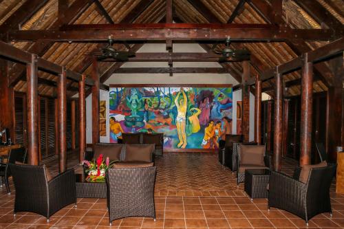 a room with chairs and a large painting on the wall at ROYAL BORA BORA in Bora Bora