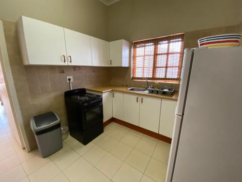 a kitchen with white cabinets and a black refrigerator at Lanseria Country Estate in Lanseria