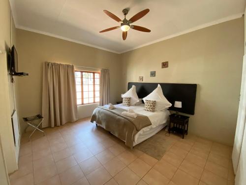 a bedroom with a bed and a ceiling fan at Lanseria Country Estate in Lanseria