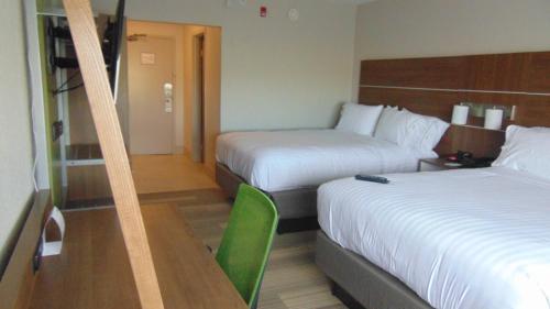 a hotel room with two beds and a table at Holiday Inn Express & Suites Wapakoneta by IHG in Wapakoneta
