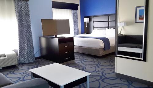 a small hotel room with a bed and a couch at Holiday Inn Express Hotel & Suites Lawrenceville by IHG in Lawrenceville