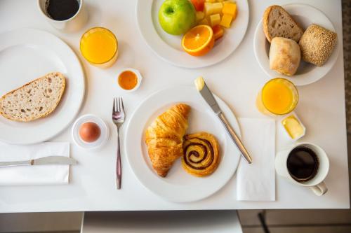 a white table with plates of breakfast food on it at Holiday Inn Express Amsterdam - Schiphol by IHG in Hoofddorp