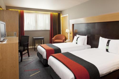 a hotel room with two beds and a television at Holiday Inn Aberdeen West by IHG in Westhill 