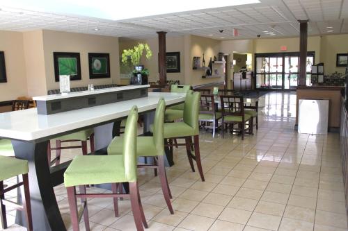 a restaurant with green chairs and a counter in a room at Comfort Inn & Suites in Asheboro