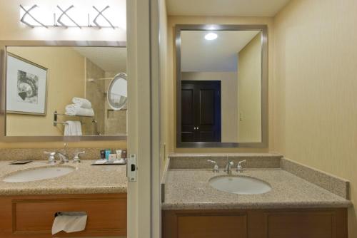 a bathroom with two sinks and a large mirror at Albuquerque Crowne Plaza by IHG in Albuquerque