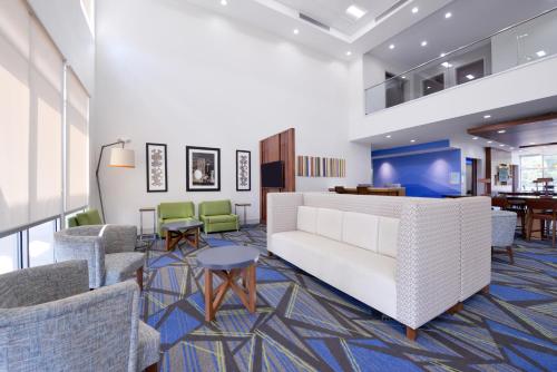a lobby with a white couch and chairs at Holiday Inn Express - Bethlehem by IHG in Winder